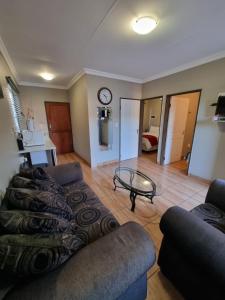 ein Wohnzimmer mit einem Sofa und einem Tisch in der Unterkunft The Cape Lodge in Upington