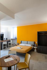 una camera con un letto con una parete gialla di Duomo Guest House a Barletta