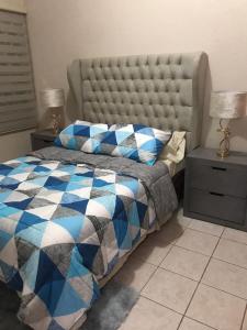 a bedroom with a bed with a blue and white comforter at Casa Vacacional Boca II in Boca del Río