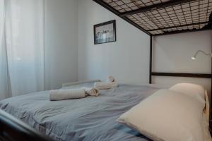 1 dormitorio con 1 cama con toallas en Attico vista mare - Centro-Park, en Trieste