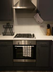 a kitchen with a stove top oven in a kitchen at Cosy Modern Flat (NEC/BHX Stays) in Marston Green