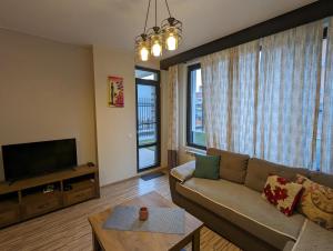 a living room with a couch and a flat screen tv at Business and Leisure apartments in Mladost 2 with FREE Garage in Sofia