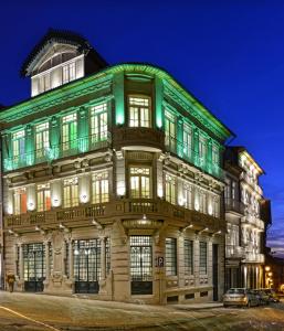 un edificio con luces verdes en el lateral. en EMAJ Boutique Hotel, en Guimarães