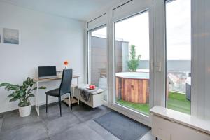 an office with a desk and a table with a window at Das Penthouse - Jacuzzi - BBQ - Dachterrasse in Karlsruhe