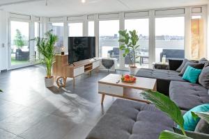 uma sala de estar com um sofá e uma televisão em Das Penthouse - Jacuzzi - BBQ - Dachterrasse em Karlsruhe