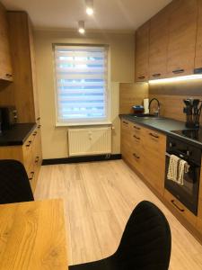 a kitchen with wooden cabinets and a window and a table at VIP Apartment 4A 2 Zi 40qm Küche Bad in Vierraden