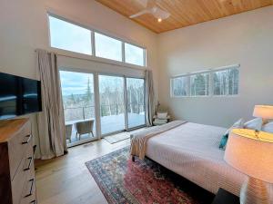 a bedroom with a bed and a large window at 1A Maple Lodge Stunning luxury Scandinavian style home with great views in Bethlehem