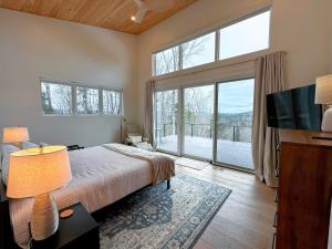 ein Schlafzimmer mit einem Bett und einem großen Fenster in der Unterkunft 1A Maple Lodge Stunning luxury Scandinavian style home with great views in Bethlehem