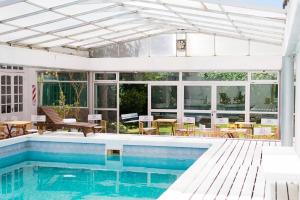 an outdoor pool with a pergola and a house at SH Hotel & Spa de Mar Samay Huasi in Puerto Madryn