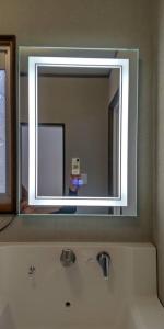 a mirror above a sink in a bathroom at Villa Hikone Castle ヴィラ彦根キャッスル 彦根城9分 10人泊 キャッスルロード4分 ひこにゃん4分 駐車3台 ビワイチ in Hikone