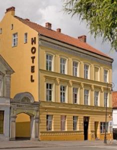 żółty budynek z znakiem na boku w obiekcie SHotels przy Restauracji Stodoła w mieście Bartoszyce