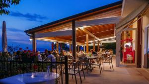 een groep mensen die aan een tafel op een patio zitten bij Camping Belvedere in Lazise