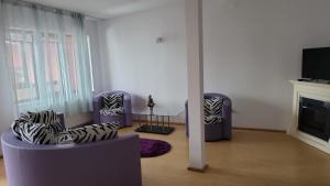 a living room with two chairs and a fireplace at Central Apartament Predeal Nr 6 in Predeal