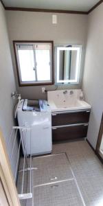 a bathroom with a sink and a mirror and a washing machine at Villa Hikone Castle in Hikone