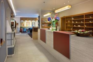 a lobby with a counter with a vase of flowers at Arabella Alpenhotel am Spitzingsee, a Tribute Portfolio Hotel in Spitzingsee
