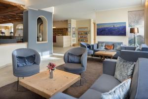 a living room with blue chairs and a table at Arabella Alpenhotel am Spitzingsee, a Tribute Portfolio Hotel in Spitzingsee