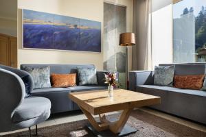 a living room with couches and a coffee table at Arabella Alpenhotel am Spitzingsee, a Tribute Portfolio Hotel in Spitzingsee +37 photos