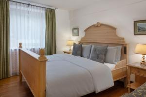 a bedroom with a large white bed and a window at Arabella Alpenhotel am Spitzingsee, a Tribute Portfolio Hotel in Spitzingsee