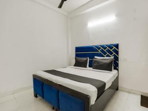uma cama azul e branca num quarto em OYO Happy Home Residency em Nova Deli