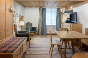 a living room with a table and a dining room at Arabella Alpenhotel am Spitzingsee, a Tribute Portfolio Hotel in Spitzingsee