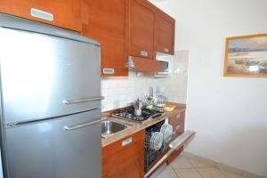 uma cozinha com um frigorífico de aço inoxidável e um lavatório em Coastal escape modern flat with Wi-Fi em Bibione