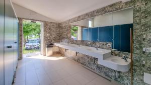 uma casa de banho com 2 lavatórios e armários azuis em Camping Belvedere em Lazise
