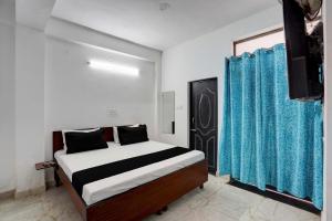 um quarto com uma cama e uma cortina azul em Super OYO HOTEL LUV PALACE em Ghaziabad