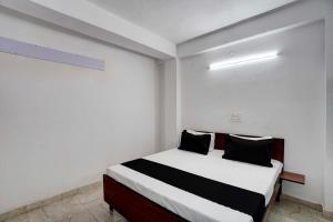 um quarto com uma cama com lençóis brancos e pretos em Super OYO HOTEL LUV PALACE em Ghaziabad