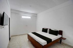 um quarto com uma cama e uma televisão em Super OYO HOTEL LUV PALACE em Ghaziabad