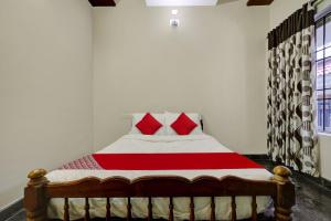 a bedroom with a bed with red pillows on it at OYO Hi 5 Apartments in Cochin