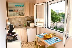 Una pequeña cocina con una mesa y una ventana. en Kaponia's Houses, en Aegina Town