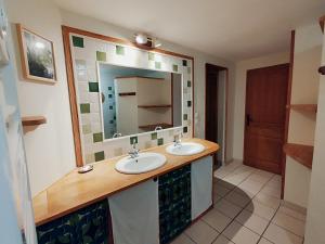 un baño con dos lavabos y un espejo en Gîte de la Barlière, en Secondigny