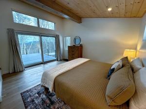 um quarto com uma cama grande e uma janela grande em 1B Contemporary cabin in magnificent setting, luxury and comfort, hot tub, AC! em Bethlehem