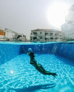 a woman in the water in a swimming pool at Meandros Boutique & Spa Hotel - Adults Only in Kalamaki