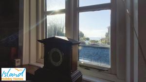 um relógio em frente a uma janela com vista em The Clock Tower em Ventnor