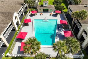 an overhead view of a swimming pool with red umbrellas at Amazing hotel room near Disney for 4 people in Kissimmee