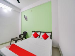 a bedroom with a bed with red and white pillows at OYO SPOT ON Urvi Castle in Bhopal