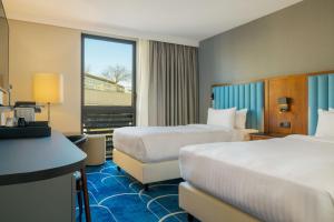 a hotel room with two beds and a window at Courtyard by Marriott Paris Arcueil in Arcueil