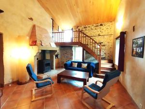 sala de estar con escalera, sofá y sillas en Gîte de la Barlière, en Secondigny