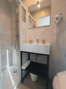 y baño con lavabo y espejo. en Hotel d'Ostende, en Niza