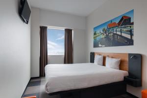 a hotel room with a bed and a window at easyHotel Amsterdam Zaandam in Zaandam
