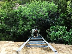 a man is climbing over a set of stairs at Eingedi Retreat in Kommissiepoort