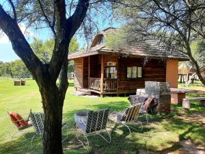 une cabane en rondins avec des chaises en face de celle-ci dans l'établissement Eingedi Retreat, à Kommissiepoort