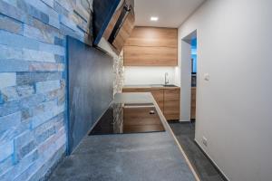 a kitchen with a brick wall and a wooden table at TEMPFER Apartments & Rooms with new WELLNESS in Rateče