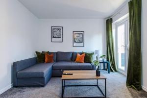 sala de estar con sofá azul y mesa en Modern 3 BR Olive Suite - Sleeps 7 en Clock Face
