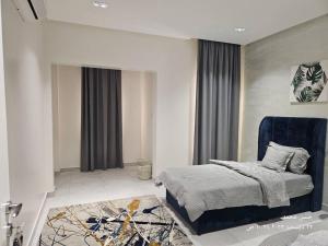 1 dormitorio con 1 cama y 1 silla azul en حي الامواج العزيزية, en Raʼs Munaysif