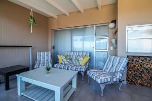 a living room with two chairs and a table at Belle Vue Ridge BnB, in Plettenberg Bay