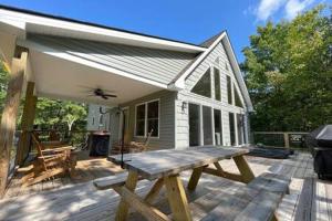 ein Picknicktisch auf einer Terrasse vor einem Haus in der Unterkunft Evergreen Escape - Jim Thorpe Multi Ski Resort in Albrightsville