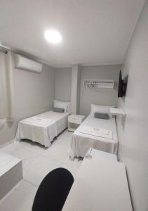 a hospital room with two beds and a tv at Pousada Chapada do Araripe in Araripina