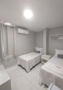 a hotel room with two beds and a window at Pousada Chapada do Araripe in Araripina